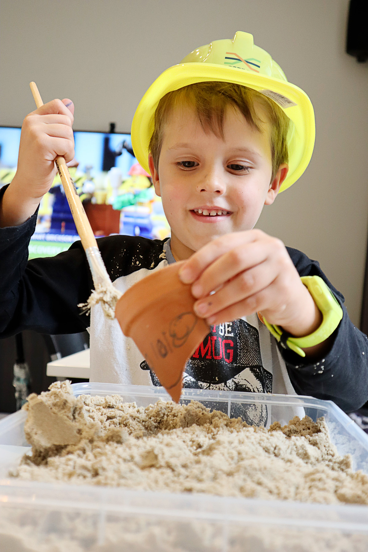 Child partakin in the Clay Pot Excavation activity.