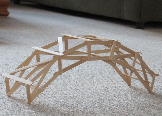 Popsicle bridge assembled on white table.